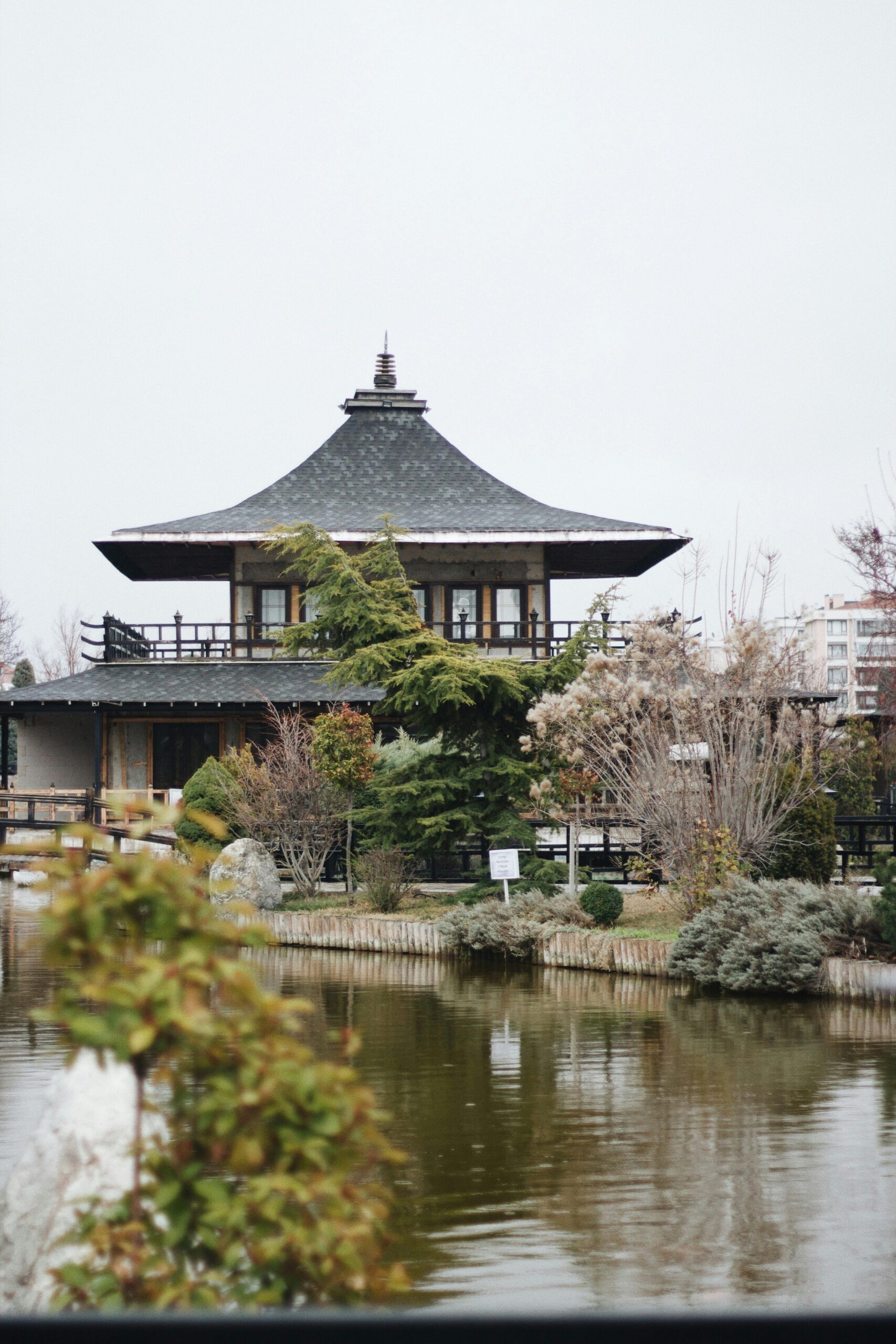 A serene Japanese temple reflected in the tranquil waters of a garden pond.