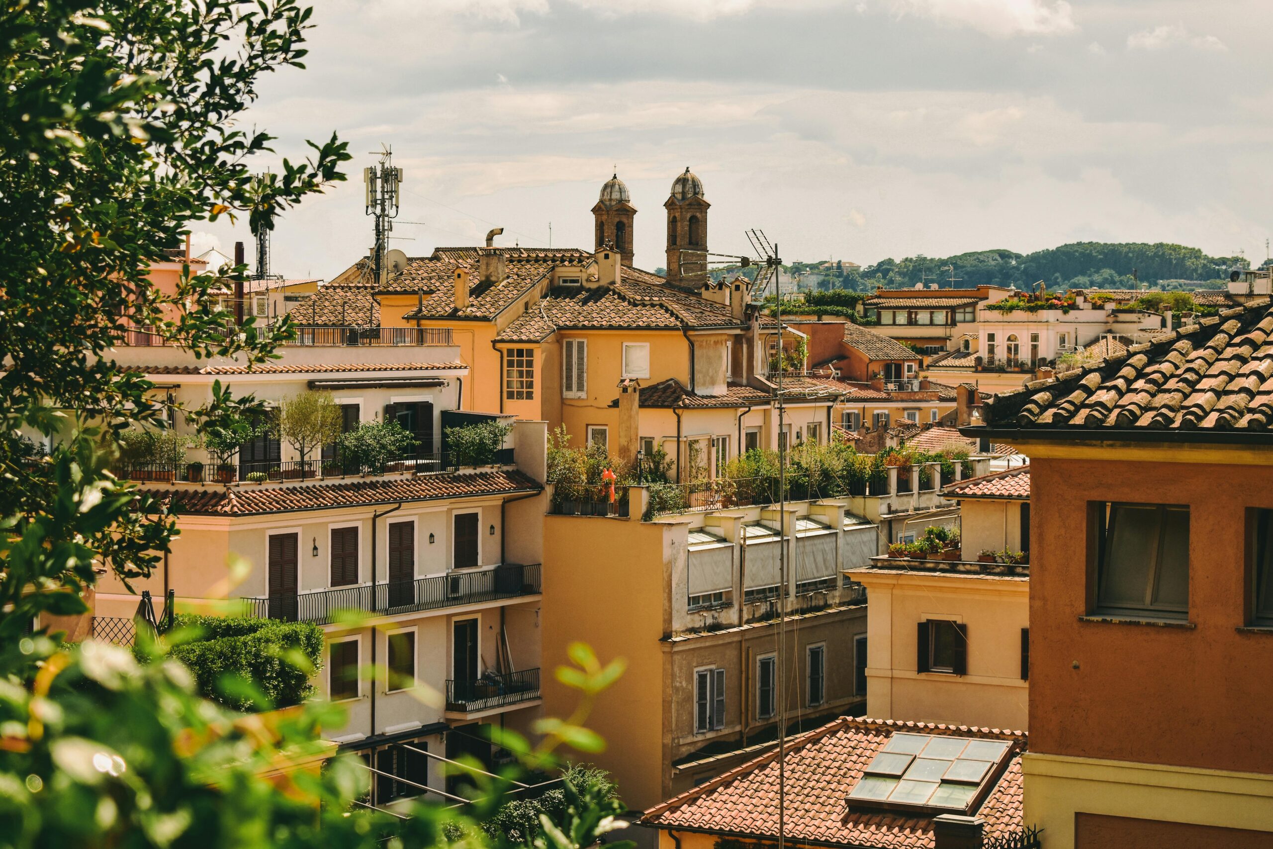 A beautiful view of Roman rooftops with historic architecture and lush greenery.