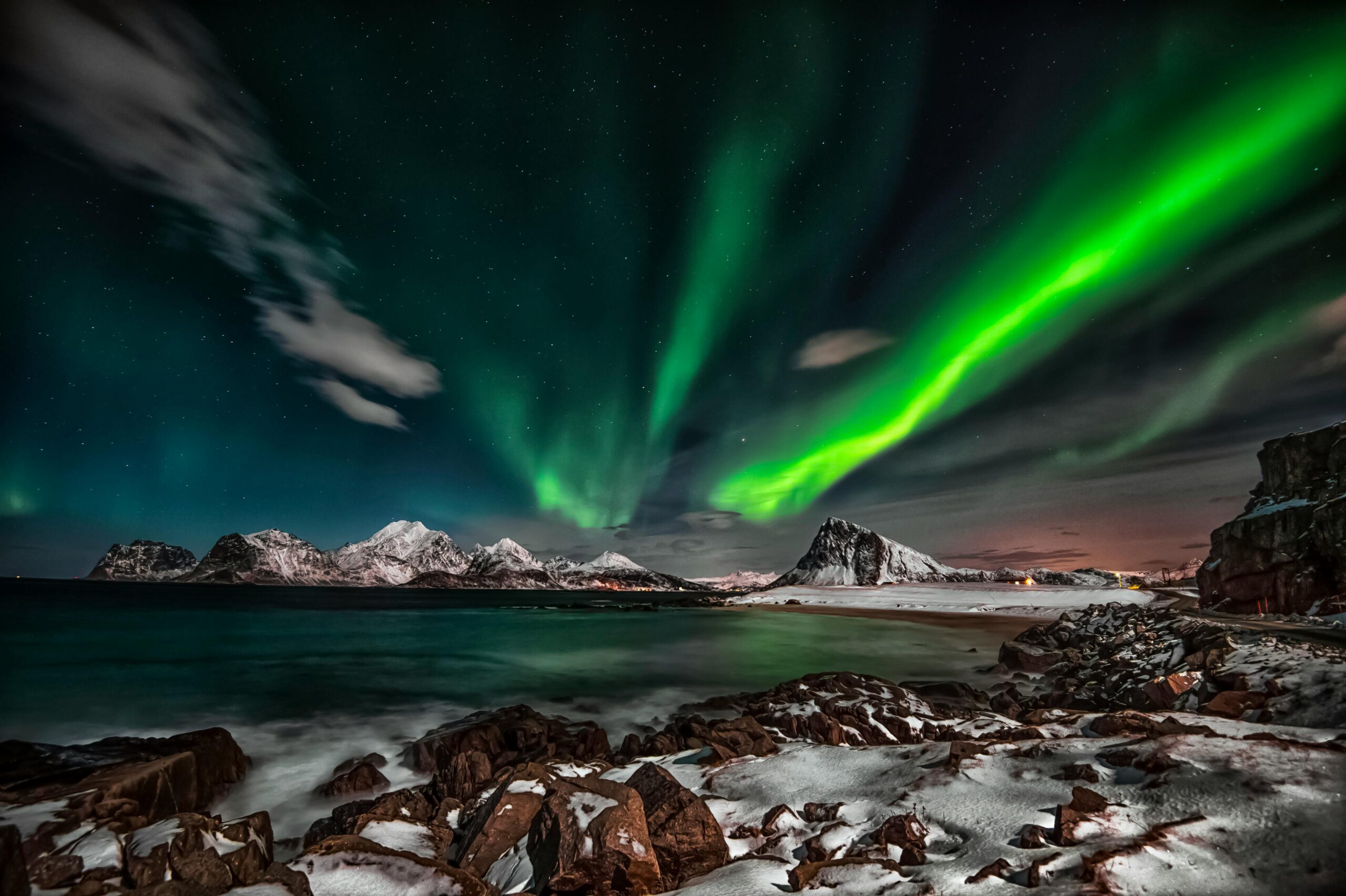 Captivating view of the Northern Lights over snow-covered Lofoten Islands at night.