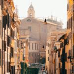 Picturesque street scene in Rome, Italy, showcasing historic architecture and a warm sunset glow.