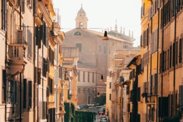Picturesque street scene in Rome, Italy, showcasing historic architecture and a warm sunset glow.