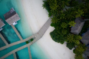 A stunning aerial view of a tropical beach resort with turquoise waters and lush greenery.